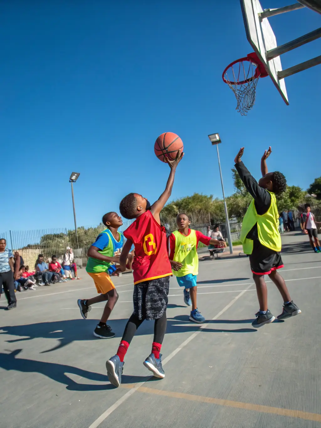 A dynamic shot of older children engaged in a competitive basketball scrimmage, showcasing teamwork and strategic play at AS Vezin Basket.